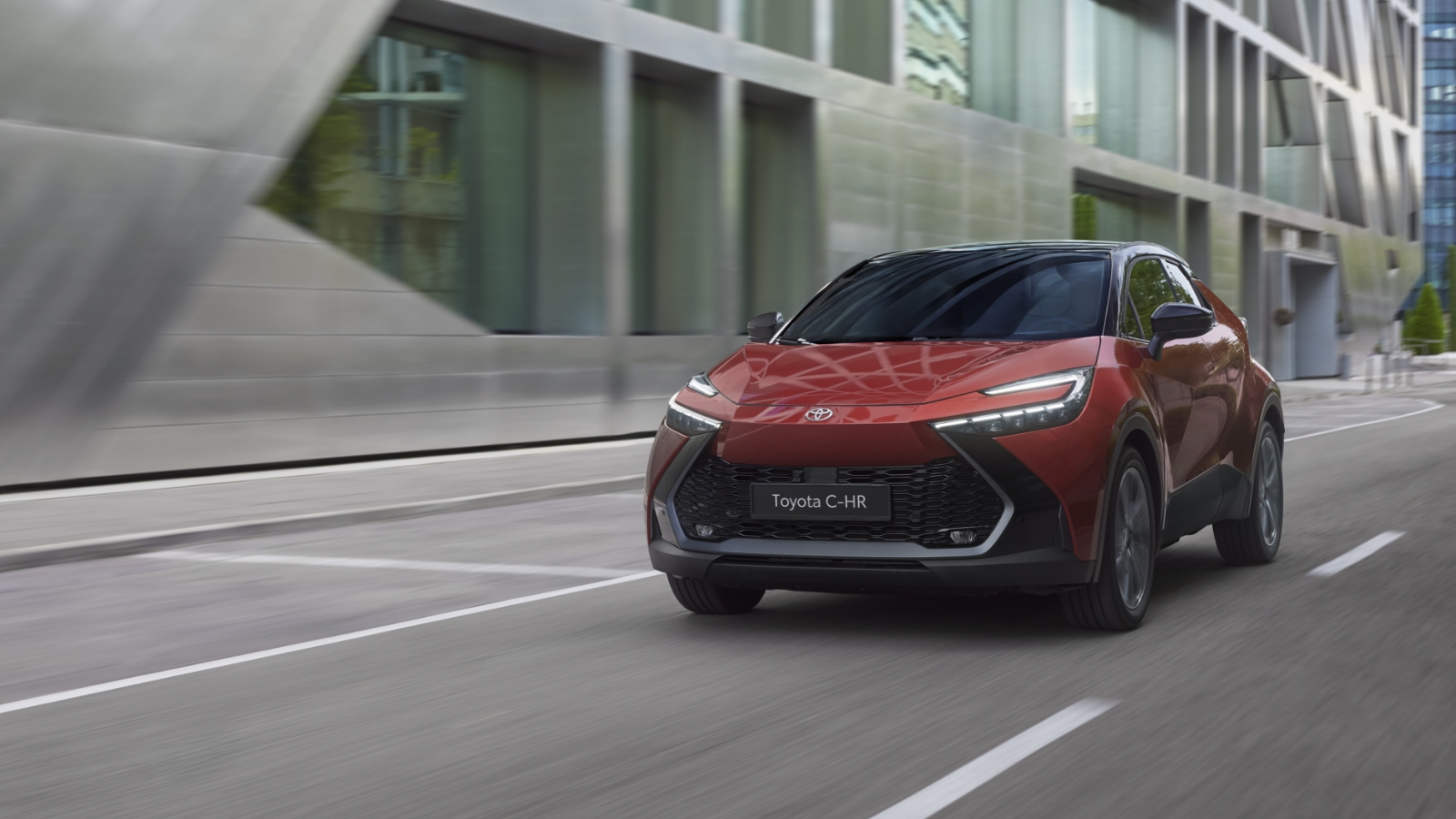 Czerwony Toyota C-HR jedzie ulicą